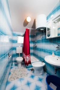 Baño de azulejos azules con aseo y lavamanos en Apartments Care en Donji Okrug