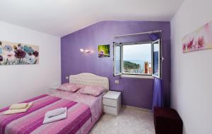 a purple bedroom with a bed and a window at Apartments Care in Okrug Donji +36 photos
