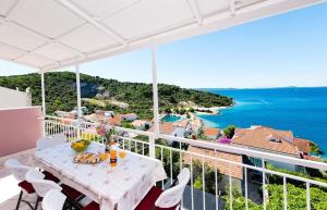 a table on a balcony with a view of the ocean at Apartments Care in Okrug Donji