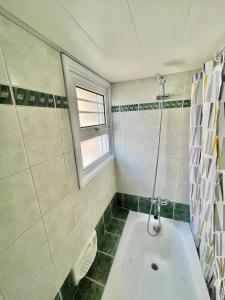 ein Bad mit einer Badewanne und einem Fenster in der Unterkunft Two Bedroom City Seaside Apartment in Limassol