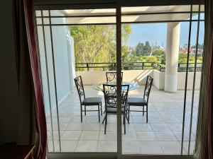 eine Terrasse mit einem Tisch und Stühlen auf dem Balkon in der Unterkunft Two Bedroom City Seaside Apartment in Limassol