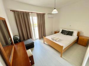 ein Schlafzimmer mit einem Bett, einem Sofa und einem Fenster in der Unterkunft Two Bedroom City Seaside Apartment in Limassol