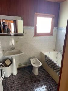 une personne prenant une photo d'une salle de bains avec lavabo et toilettes dans l'établissement Chalet situé au grand Valtin, à Ban-sur-Meurthe-Clefcy