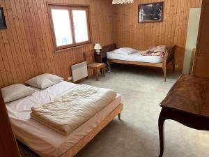 1 dormitorio con 2 camas, mesa y ventana en Chalet situé au grand Valtin, en Ban-sur-Meurthe-Clefcy