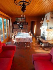 comedor con mesa y sofá rojo en Chalet situé au grand Valtin, en Ban-sur-Meurthe-Clefcy
