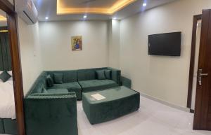 sala de estar con sofá y TV en Premier Heights, en Jhelum