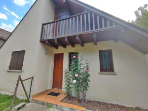 Cette petite maison blanche dispose d'un balcon et d'une porte. dans l'établissement Le chant de la Pique, maison T4, jardin, parking gratuit, wifi, 6 personnes, à Luchon