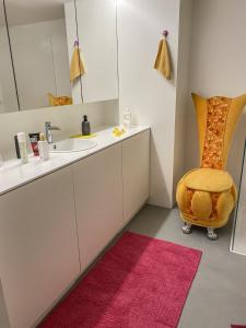 a bathroom with a sink and a chair at Loft Designer in Neuhausen am Rheinfall