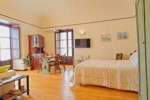 a bedroom with a bed and a table and a kitchen at OdeonHouse - Catania in Catania