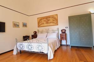a bedroom with a white bed and a television at OdeonHouse - Catania in Catania