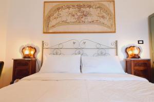 1 dormitorio con 1 cama blanca y 2 mesitas de noche en OdeonHouse - Catania, en Catania