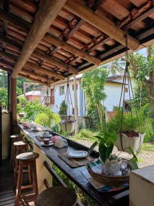 un patio con una mesa larga con plantas. en Pousada Arraial Suites en Arraial d'Ajuda