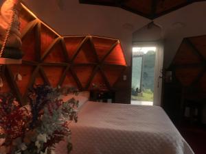 a bedroom with a large bed with a wooden headboard at PrivaDome in Rionegro