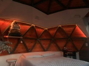 a bed in a room with a wooden headboard at PrivaDome in Rionegro