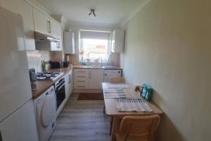 a small kitchen with a table and a stove top oven at Bright & Lovely & apartment in Whetstone