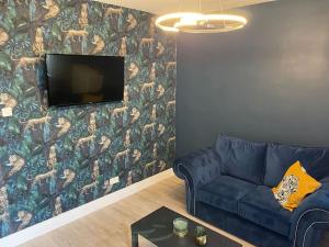 a living room with a couch and a tv on a wall at Luxury accommodation. in Wallasey