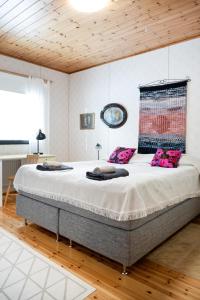 un grande letto in una camera da letto con soffitto in legno di Lepikko - Helppoa majoitusta, Easy accommodation ad Alajärvi