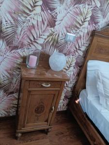 uma mesa de cabeceira com um candeeiro ao lado de uma cama em Cà Milene Bed and Breakfast em Castellinaldo