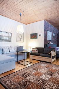 uma sala de estar com um sofá e uma mesa em Lepikko - Helppoa majoitusta, Easy accommodation em Alajärvi