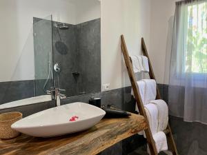 La salle de bains est pourvue d'un lavabo sur un comptoir en bois. dans l'établissement Tangawizi Villa with Private Pool ZanzibarHouses, à Kiwengwa