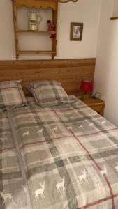 ein Bett mit einer Decke mit Hirsch drauf in der Unterkunft Studio PRAZ SUR ARLY in Praz-sur-Arly