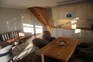 un soggiorno con tavolo e cucina di Haus-Berthin-Bleeg-App-6 a Wenningstedt