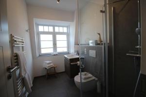 bagno con servizi igienici, lavandino e finestra di Haus-Berthin-Bleeg-App-6 a Wenningstedt