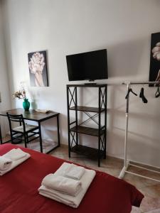 a room with a bed with a television and a table at Home Sweet Home COSENZA in Cosenza