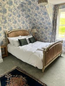 a bedroom with a large bed with blue wallpaper at Luxury Loch Tay Lodge in Aberfeldy