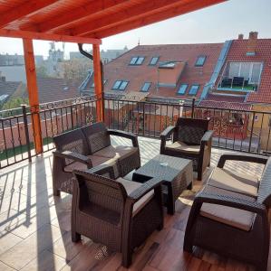 un patio con sillas y mesas en un balcón en Hotel Barbakán, en Pécs