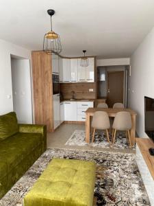 Apartman Green في Šišava: غرفة معيشة مع أريكة خضراء وطاولة