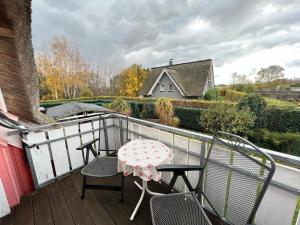 a patio with a table and chairs on a balcony at Buhne IV OG in Wieck