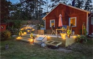 einen Hinterhof mit einem Haus und einer Terrasse mit Beleuchtung in der Unterkunft 2 Bedroom Amazing Home In Figeholm in Figeholm