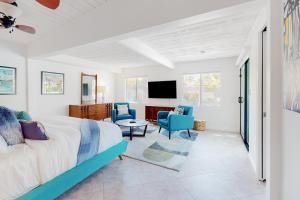 1 dormitorio con 1 cama, 2 sillas y TV en Desert Willow Mod Permit# 5268 en Palm Springs
