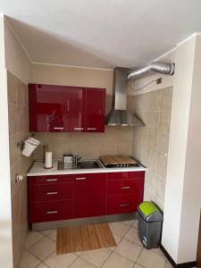 a kitchen with red cabinets and a sink at Les Deux Citrons in Limone Piemonte