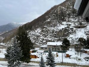 a snow covered mountain with trees and a building at Les Deux Citrons in Limone Piemonte