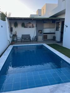 a blue swimming pool in the backyard of a house at Um Paraíso em Paripueira in Paripueira