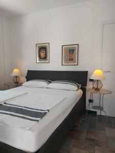 a bedroom with a large white bed with two lamps at Villa Sergio in Bardolino