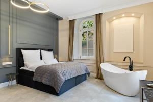 1 dormitorio con cama y bañera en BOUTIQUE ROOMS I Luxus Suite I Center I Netflix I Boxspring, en Augsburg