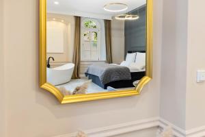 a bathroom with a mirror and a bed and a bath tub at BOUTIQUE ROOMS I Luxus Suite I Center I Netflix I Boxspring in Augsburg