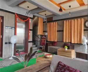 Hotel Sas Royal Galaxy By WB Inn في Yelahanka: غرفة معيشة مع أريكة وطاولة