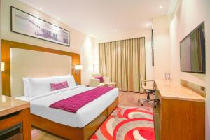 MohaliBest Western Plus Chandigarh Mohali的一间配有床和平板电视的酒店房间