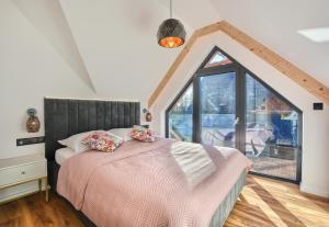 a bedroom with a bed and a large window at Santa Angela Solina Resort & SPA in Solina