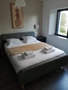 1 dormitorio con 1 cama grande y toallas. en Maison toute équipée 3 chambres avec jardin calme et Spa, en Saint-Malo