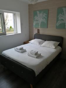1 dormitorio con 1 cama con 2 toallas en Maison toute équipée 3 chambres avec jardin calme et Spa, en Saint-Malo