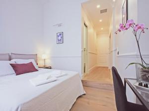 ein Schlafzimmer mit einem Bett und einem Tisch mit einer Blumenvase in der Unterkunft Gemini Suites Navona in Rom