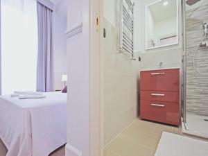 a bathroom with a shower and a bed in a room at Gemini Suites Navona in Rome