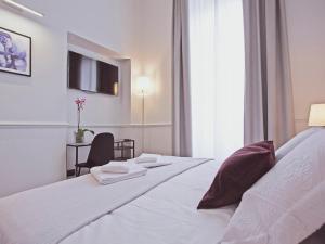 ein Hotelzimmer mit 2 Betten und einem Fenster in der Unterkunft Gemini Suites Navona in Rom