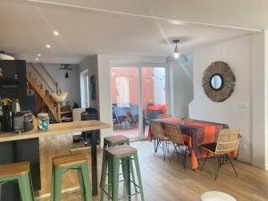 una cucina e una sala da pranzo con tavolo e sedie di Belle maison de vacances avec patio - pour 6 pers - à deux pas de la grande plage et du centre ville a Les Sables-dʼOlonne