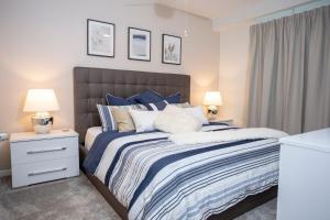 una camera da letto con un letto con lenzuola blu e bianche e due lampade di Gorgeous Two Bedroom Apto Close to Disney 306 a Kissimmee